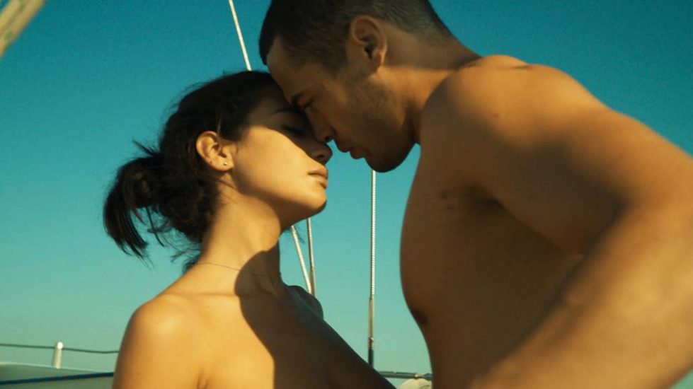 Beautiful María Pedraza topless is kissing with a guy on a boat. 